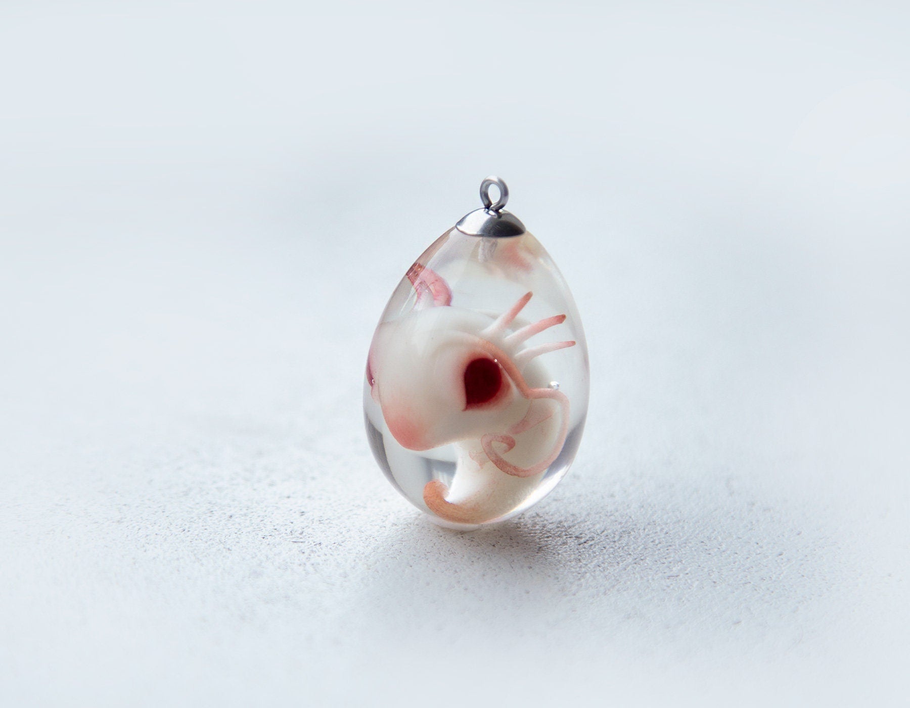 Axolotl embryo jewelry by CocoonToy. Polymer clay and resin