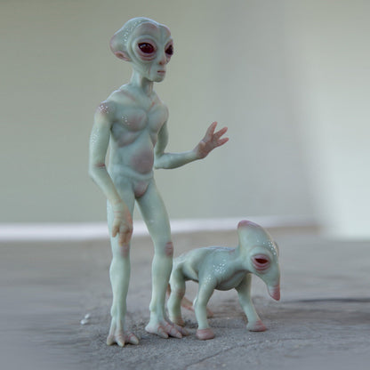 An alien from the ship that crashed in Roswell, New Mexico. He has gray skin, is a humanoid with a large head and two slanted eyes, and stands in a pose greeting earthlings. He also has his pet alien dog by his side.