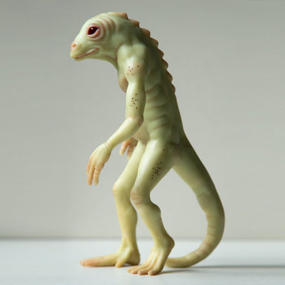 Lizard Man, a humanoid reptile from the swamps of South Carolina. It has webbed hands and feet and a long tail like a lizard. The skin color is green or yellow-green, the head of a lizard with human features. The sculpture is made of polymer and contains a steel frame