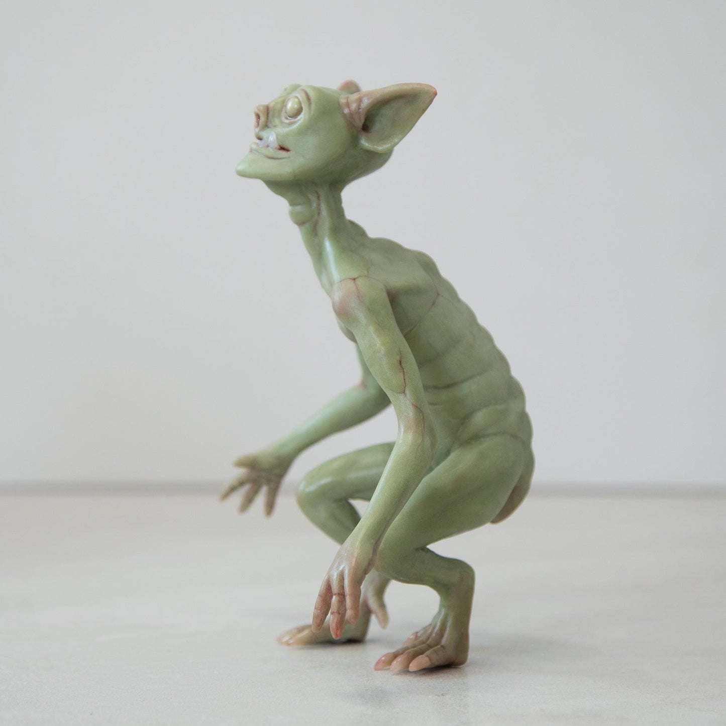 Cute green goblin sculpture with glow in the dark eyes, were created by Abigail Larson and made in our team.