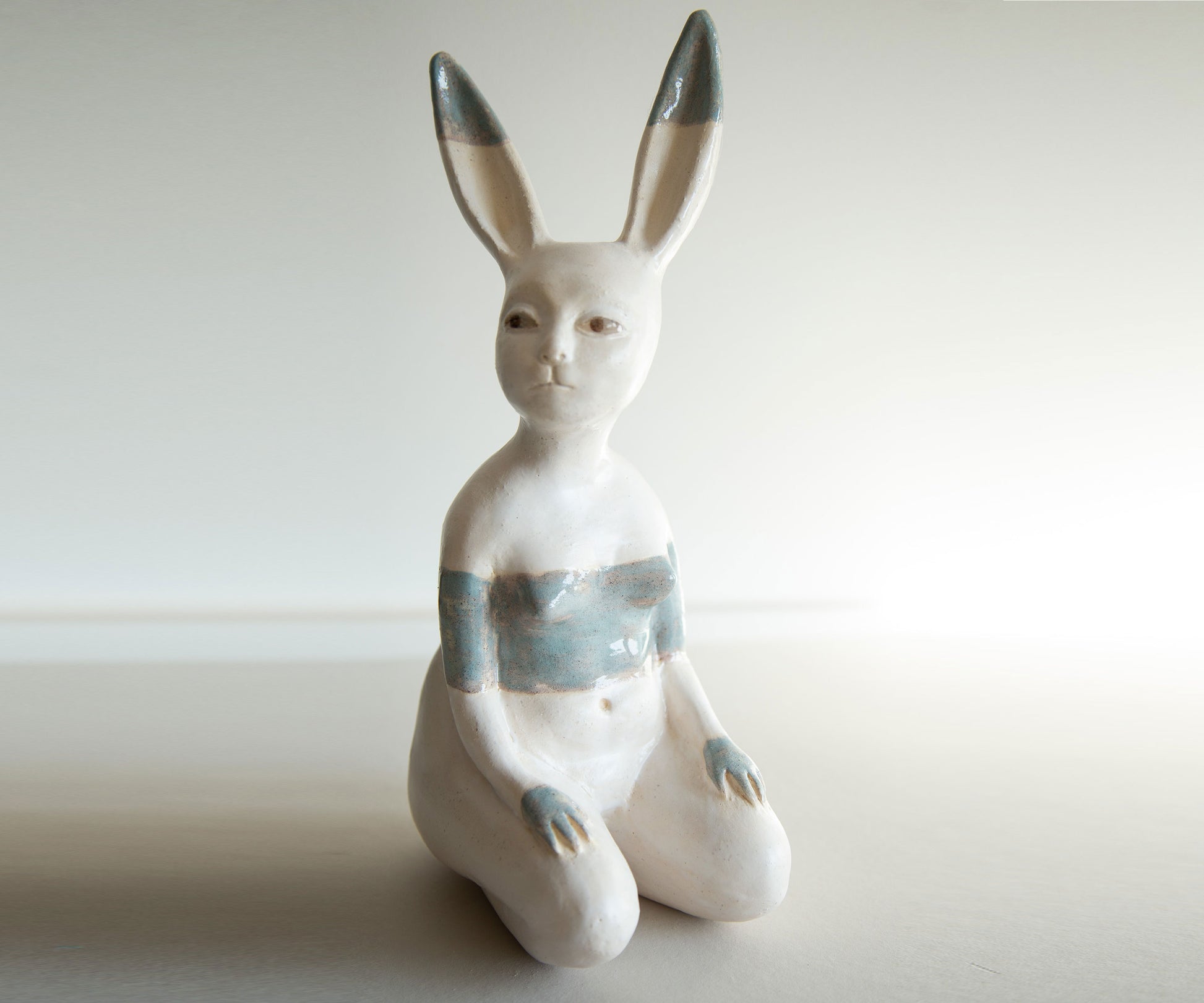 White ceramic rabbit figurine with gray accents on a light background