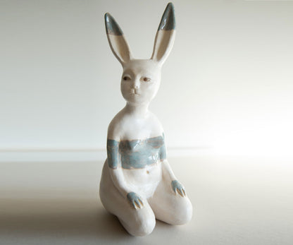White ceramic rabbit figurine with gray accents on a light background