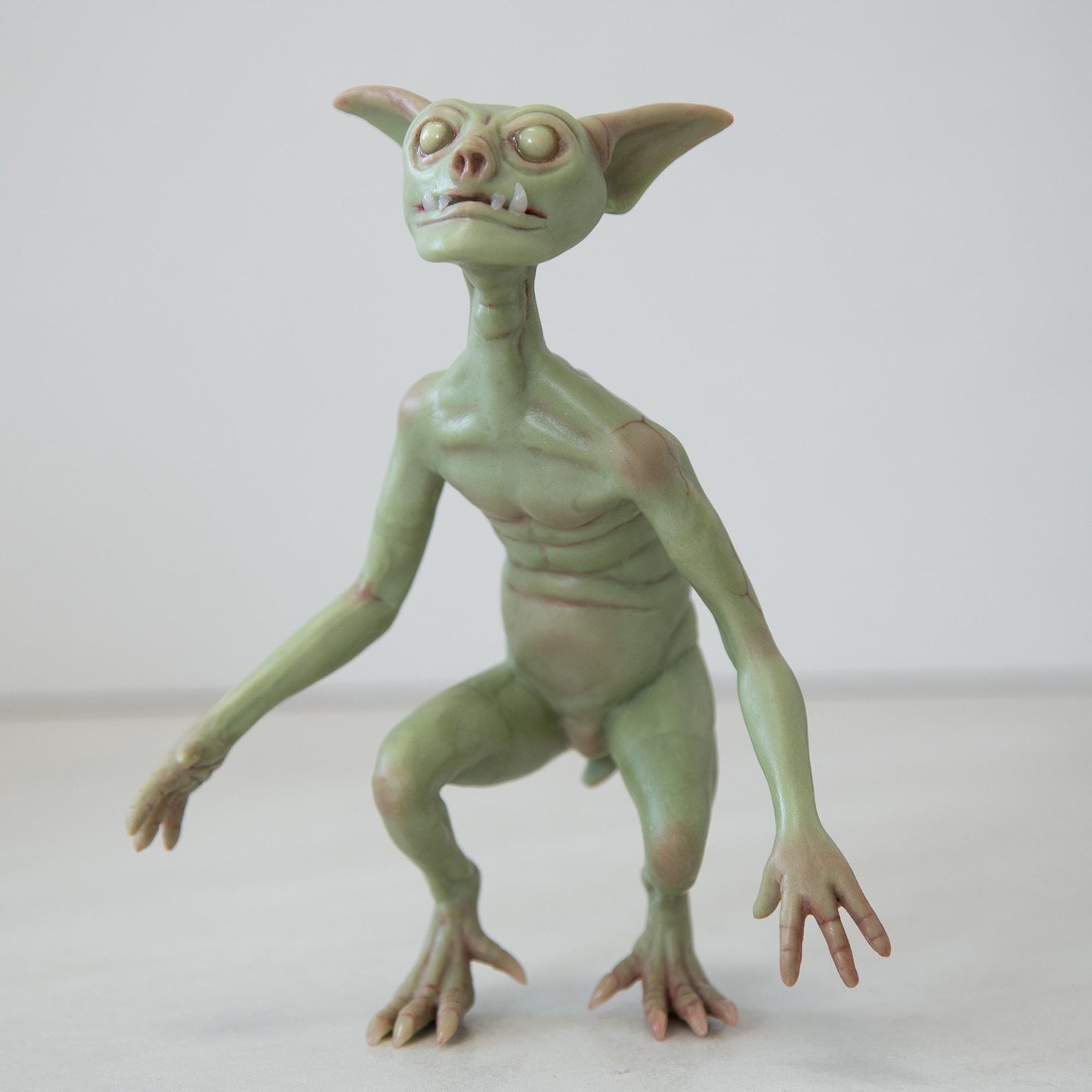 Cute green goblin sculpture with glow in the dark eyes, were created by Abigail Larson and made in our team.