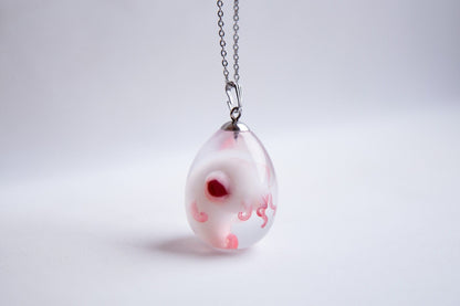 A small embryo of the mythical god Cthulhu, in a transparent pendant made of epoxy resin in the shape of an egg