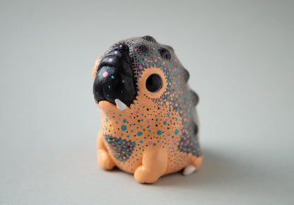 A small alien warthog, a hybrid of a puppy and a hamster, covered in hand-painted abstract style. The colors used are black, orange, blue, pink and gray.