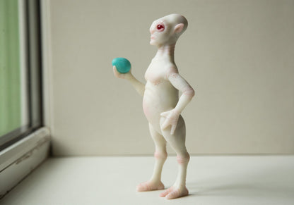 Alkari Eggtrader - fully created and made character by our art team. Reptillian alien stay and keed blue egg in his right hand. He has humanoid stature with small reptillian tail. White semi translucent skin with viens. Red eyes, made from epoxy.