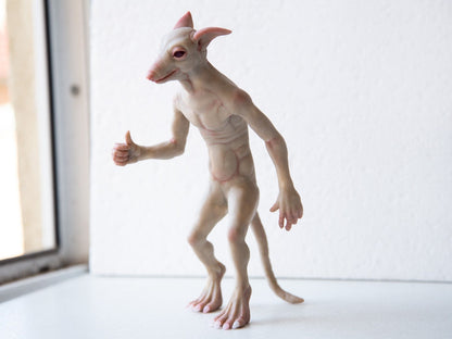 The dog man from Michigan. A character from folk tales, a hybrid of a man and a dog. He walks upright, has claws on his feet, brown fur, and a cute dog face. In our sculpture, he seems to be trying to catch a taxi, in this pose he stands. We made him friendly and smiling