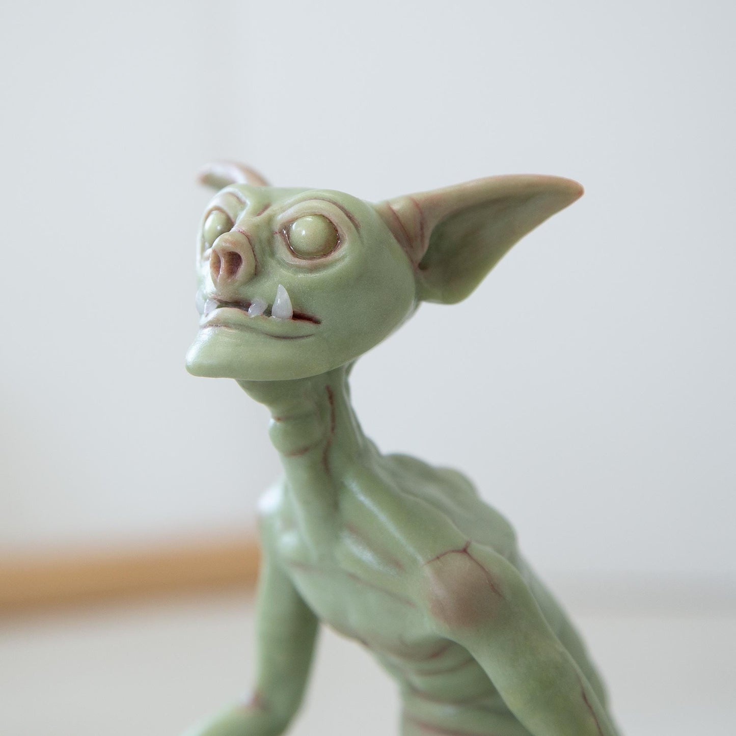 Cute green goblin sculpture with glow in the dark eyes, were created by Abigail Larson and made in our team.