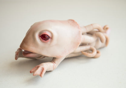 A fantastic creature from the depths of the ocean, an assistant of the god Cthulhu. He has a patsir, movable small hands and tentacles at the back. In addition, he has a tail with a fin. The sculpture is made of beige polymer, eyes of red epoxy