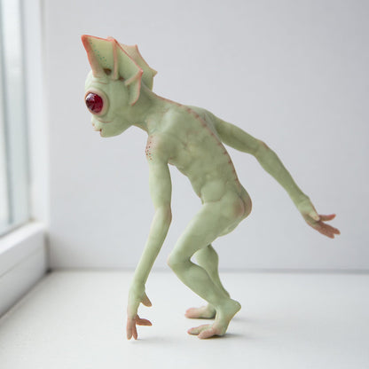 Hopkinsville Goblin or Kelly Little Green Man, a mythical creature from an urban legend in Kentucky. Skinny, with long arms, webbed ears and red eyes that glow in the dark. Green skin and a large toad-like mouth. The sculpture is made of polymer and epoxy