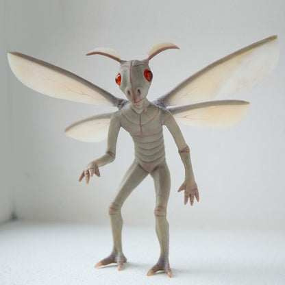 One of the most popular cryptid in USA, the Mothman from West Virginia. This sculpture made from polymer clay in light gray olive color. It has four wings, two legs and hands, partially flocked body and big cherry colored eyes. Wings made from translucent polymer