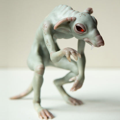 Sculpture of Chupacabra, famous and scary cryptid creature from Texas. This is hybrid animal beast, mix of wolf and rat and has vampire origin. Sculpture ade from gray polymer clay, has red epoxy eyes and vampire teath, viens and brown dots