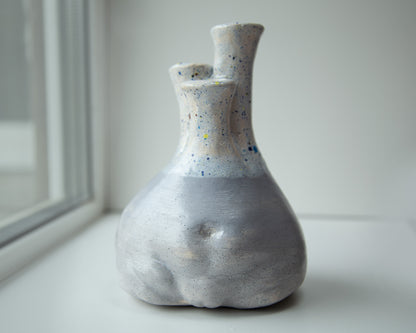 Rustic, sculptural, woman torso shaped, clay vase with earthy tones and a unique asymmetrical form, topped with a green glaze.