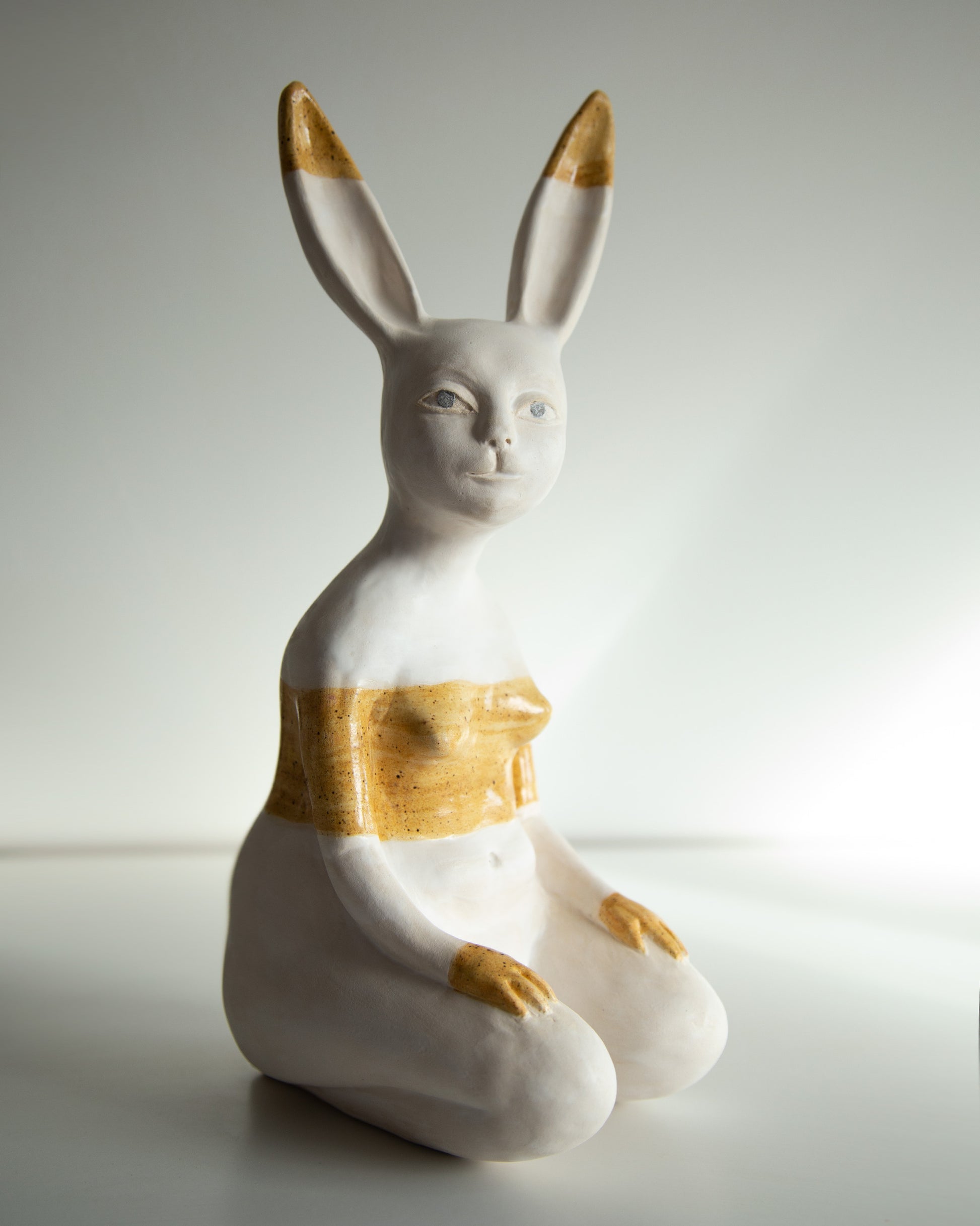 Ceramic rabbit figurine with gold accents on a white background