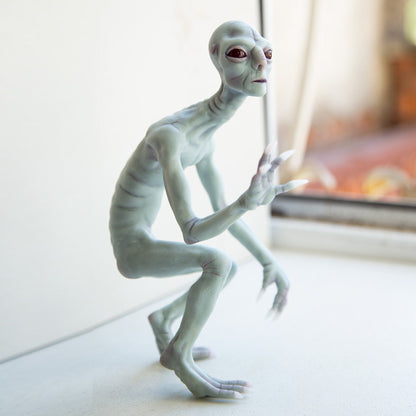 Rake Monster, a creepy humanoid from Arizona. It has gray and blue skin, a thin body, sharp long claws on its hands and feet, a long neck and red scary eyes. The sculpture is made of polymer, has a steel frame. The character was created and hand-made by our team