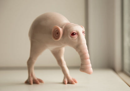 fantastic alien animal, Morsh. A hybrid of an elephant and a kiwi bird. It has a trunk, bird legs, unusual round ears and a leathery tail with folds. The sculpture is made of beige polymer, epoxy is used for the eyes