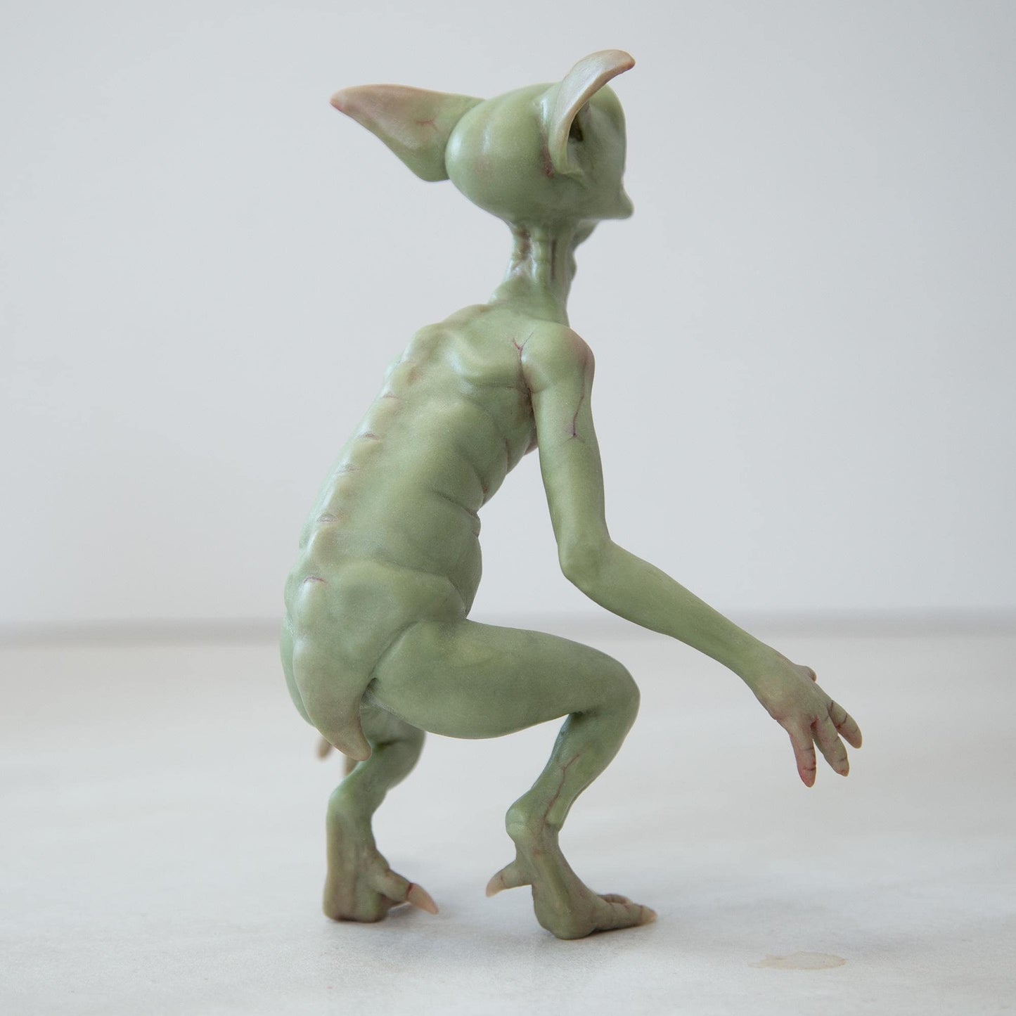 Cute green goblin sculpture with glow in the dark eyes, were created by Abigail Larson and made in our team.