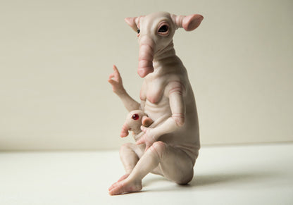 Handmade Pregnant Elephant Art Doll an elongated snout, large expressive eyes, and human-like limbs. The sculpture has a pale, textured surface