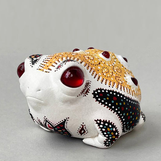 An anime style African rain frog figurine, painted with traditional African folk ornament. Traditional African colors and motifs of the ornament were used. The figurine is made of acrylic compound, then hand painted